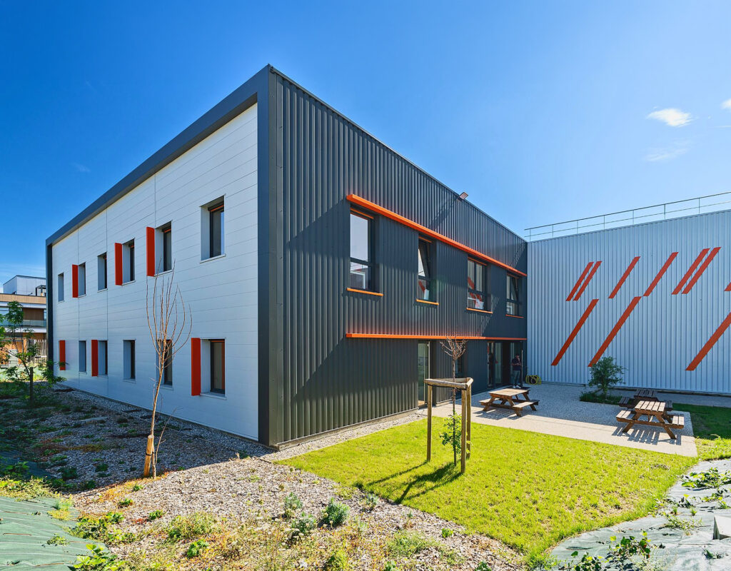 Bâtiment de bureaux et entrepôt Etandex, bardage gris et touches orange, à Genas