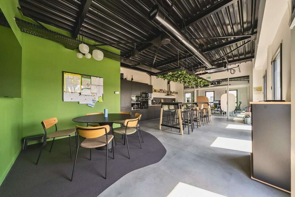 Espace de travail collaboratif chez Explorair, mur végétal et mobilier bois, à Chasse-sur-Rhône