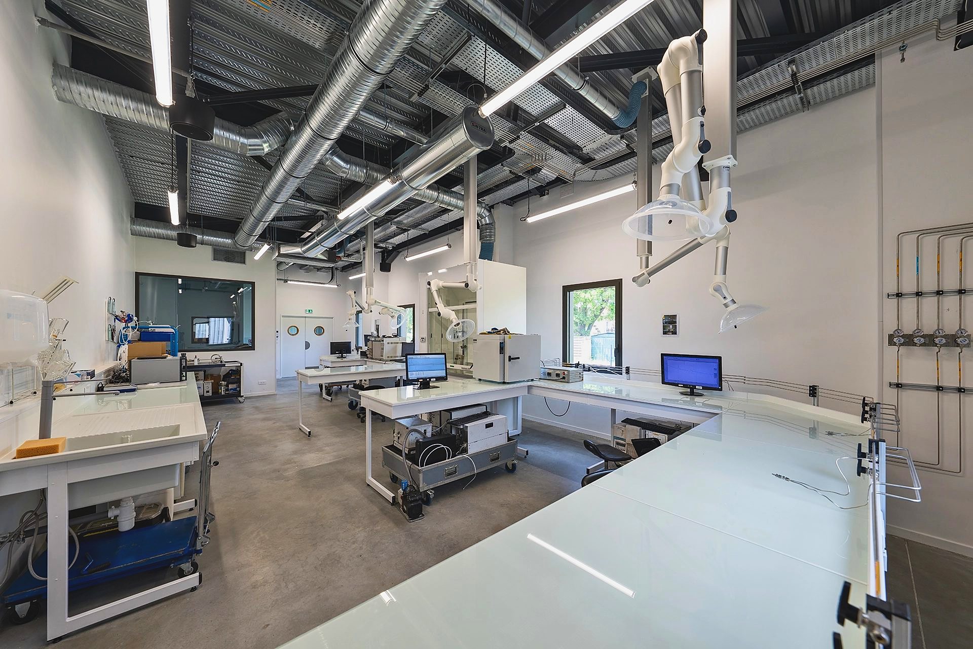 Laboratoire et atelier technique d'Explorair, gaines et bras d'aspiration au plafond, à Chasse-sur-Rhône