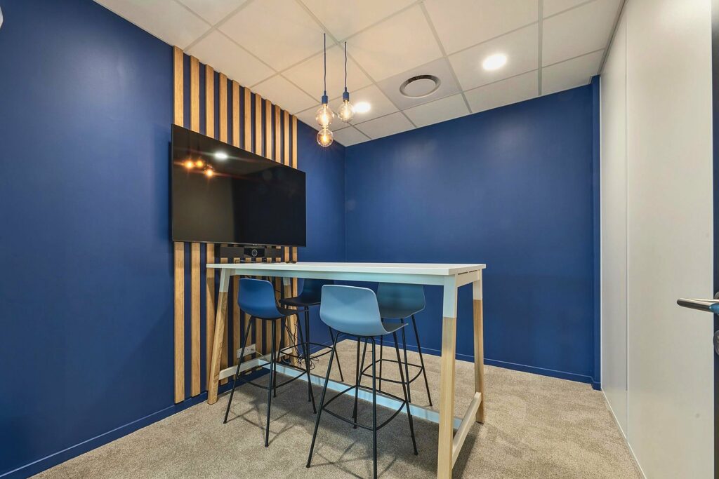 Salle de réunion au mur bleu et habillage bois chez Explorair, à Chasse-sur-Rhône