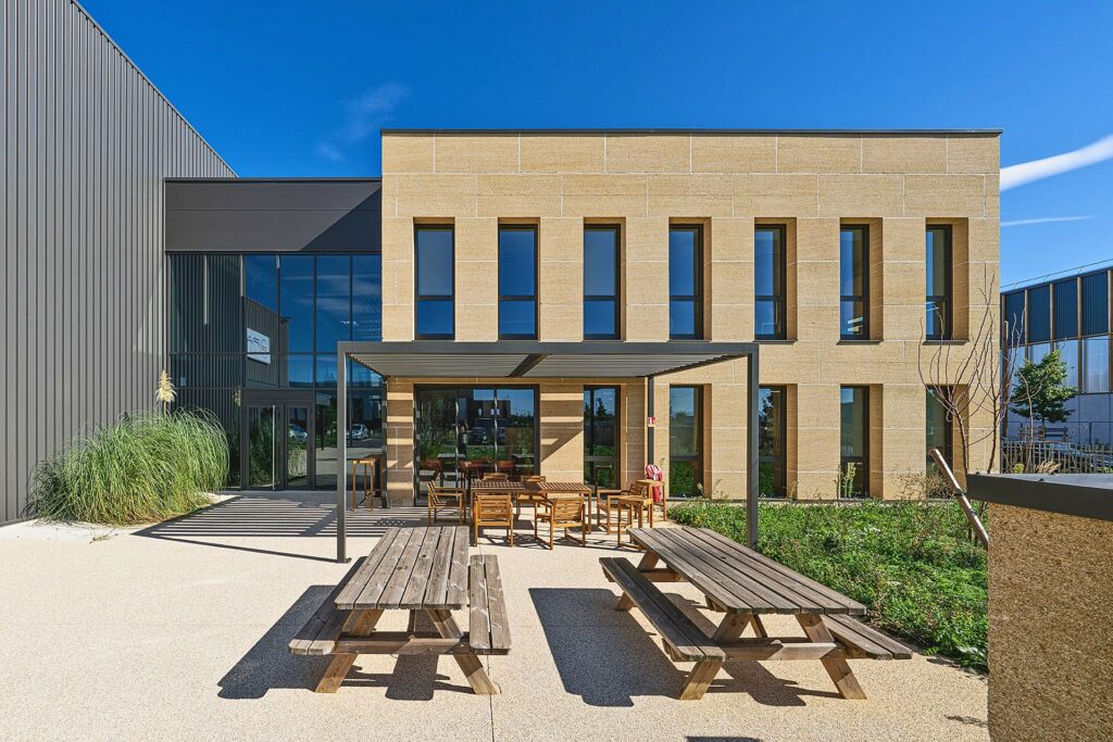 Terrasse et façade en pierre du siège de Pathel et Hydroscand, à Genas