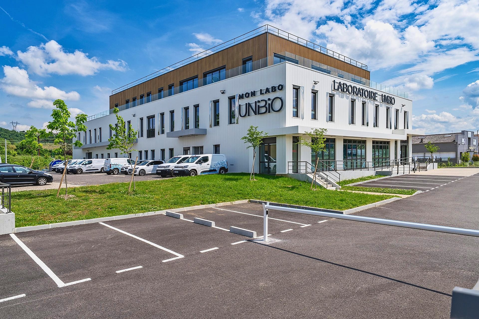 Façade et parking du laboratoire Unibio, étage en bardage bois, à Chasse-sur-Rhône